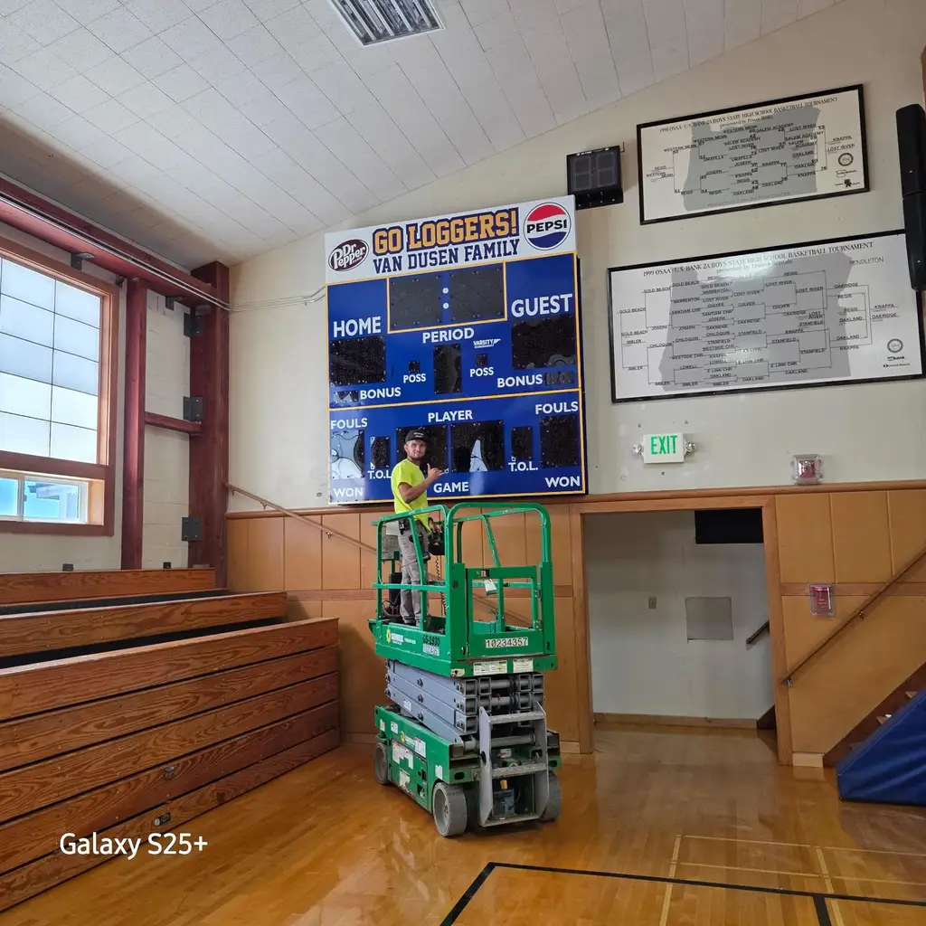 Indoor gym scoreboard installation with scissor lift
